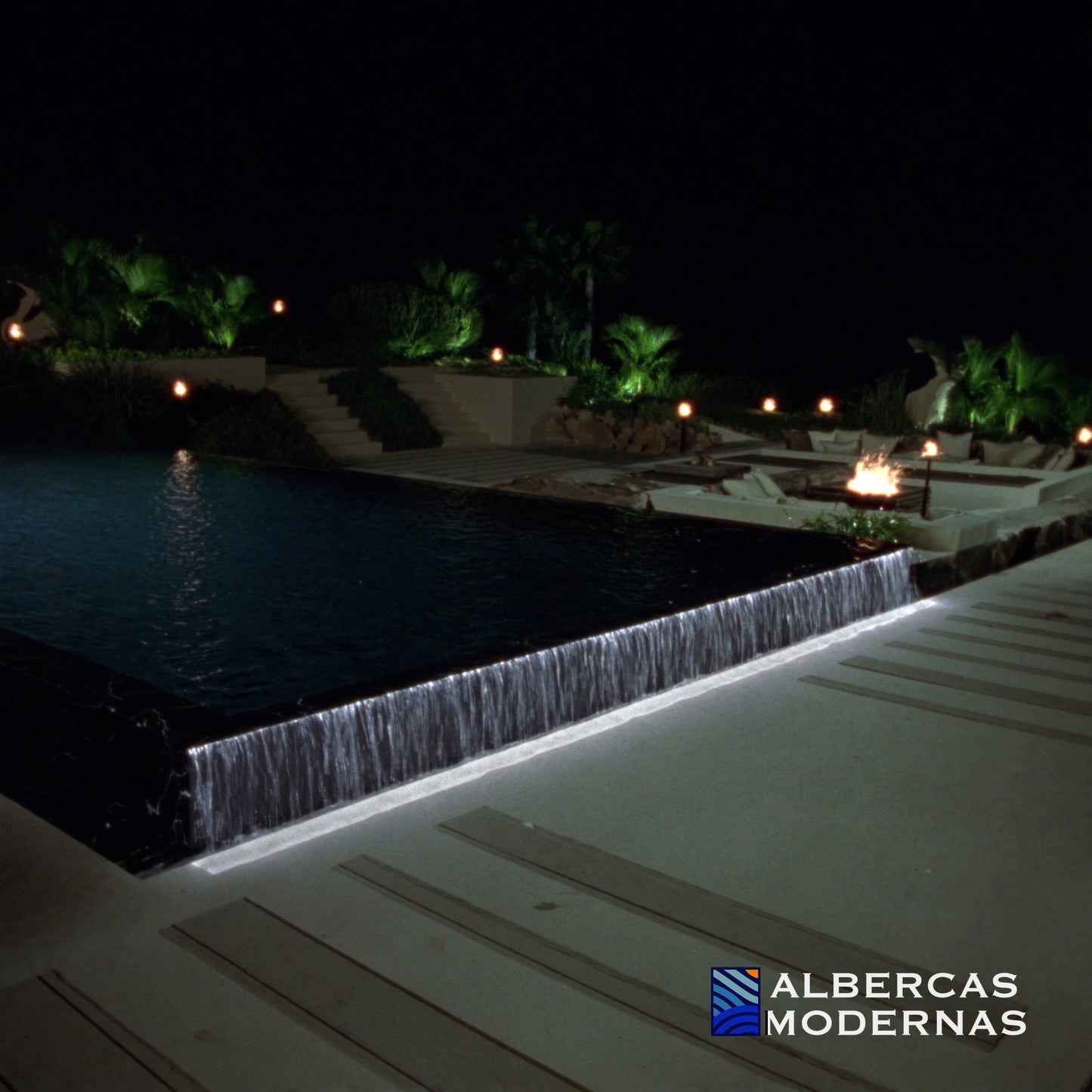 Alberca Moderna Signature con borde infinito y cascada iluminada de noche — imagen ilustrativa